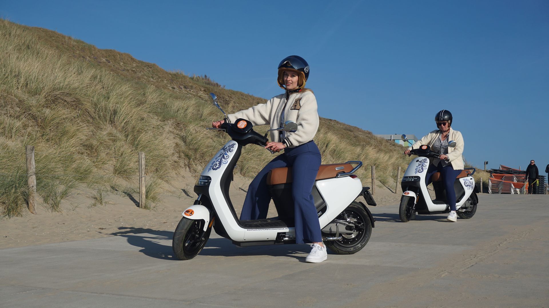 Twee huurders op elektrische scooters onderweg bij de duinen